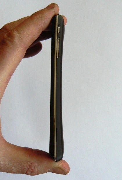 Hand holding a slim Sony Xperia J smartphone side view.