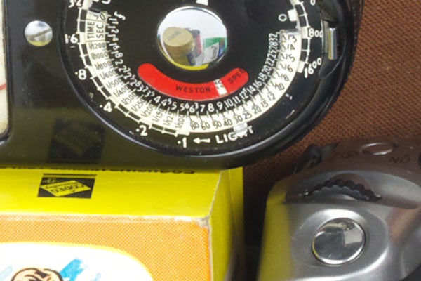 Close-up of a vintage light meter and camera body.