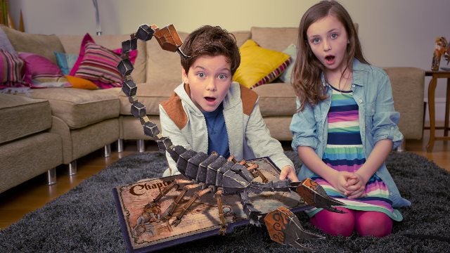 Children amazed by animated dragon coming out of Wonderbook.