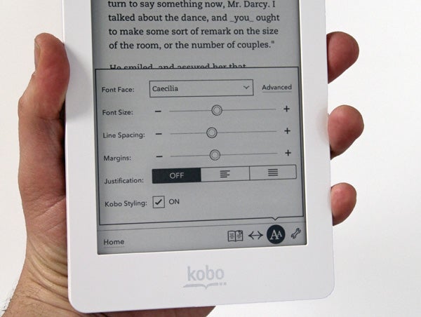 Hand holding a Kobo Glo eReader displaying font settings.