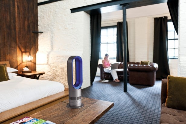 Dyson Hot AM04 heater in a cozy bedroom setting.