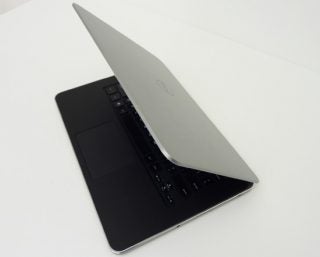 Dell XPS 14 laptop with lid partially closed on white surface.