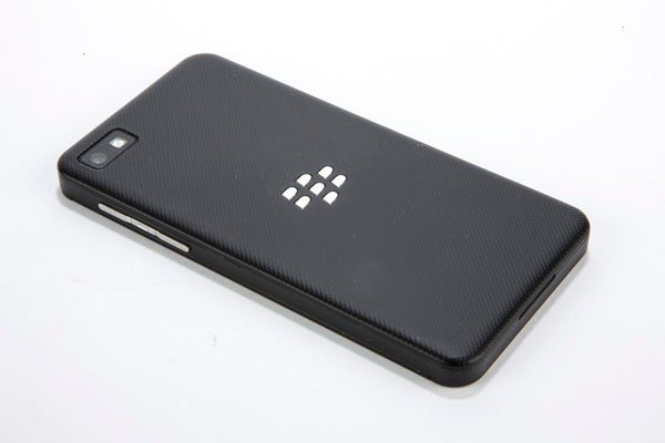 Close-up of BlackBerry Z10's upper corner and textured back.BlackBerry Z10 smartphone lying on a white surface.