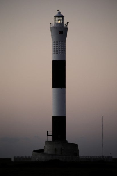 Lighthouse at dusk with clear detail and soft lighting.