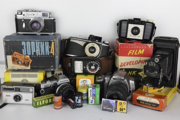 Collection of vintage cameras and photography film boxes.