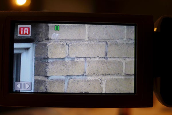 LCD screen of Panasonic HC-V520 camcorder showing brick wall.