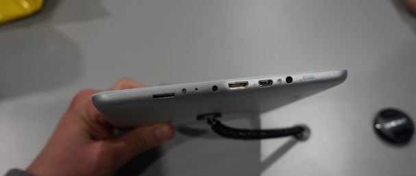 Side view of Archos 80 Titanium tablet's ports and buttons.Hand holding an Archos 80 Titanium tablet at a display booth.