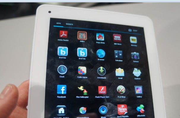 Hand holding Archos 80 Titanium tablet displaying apps.