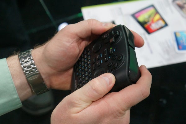 Person holding an Archos TV Connect remote control.Hand holding the Archos TV Connect remote control.