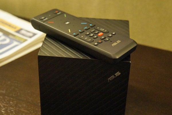 Asus Qube with remote control on top.Asus Qube with Google TV and accompanying remote control.