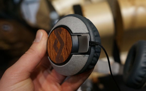 Hand holding House of Marley Liberate headphones with wood detail.