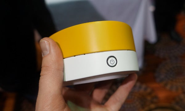 Hand holding a yellow and white Pure Jongo A140B speaker.