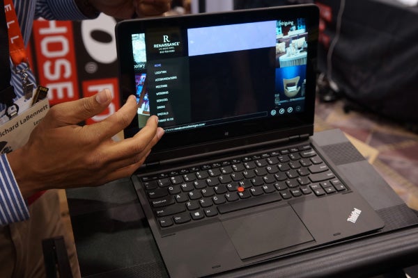 Person demonstrating Lenovo ThinkPad Helix convertible laptop.