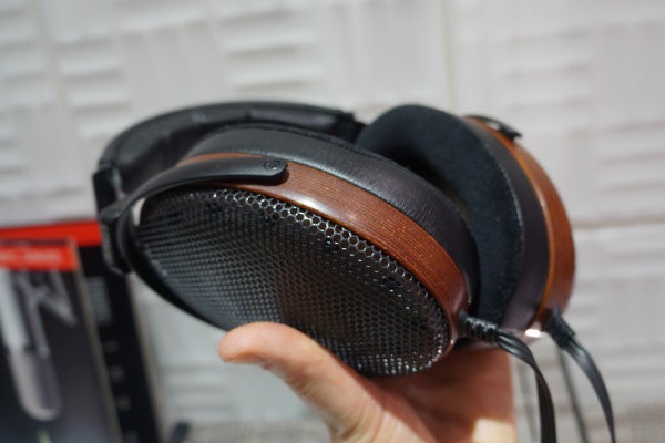 Hand holding Sennheiser Orpheus HE 90 headphones with visible texture.
