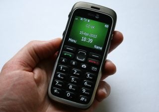 Hand holding a Doro PhoneEasy 520X mobile phone.