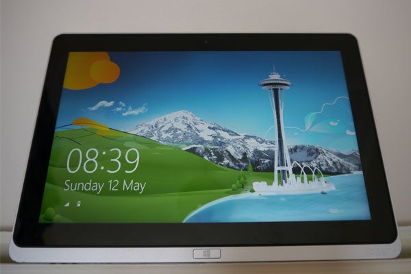 Acer Iconia W700 tablet displaying a colorful wallpaper with a clock.