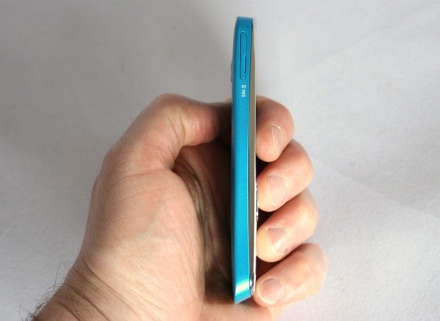 Person holding a slim blue smartphone in their hand.