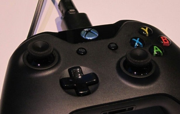 Close-up of Xbox One controller with USB cable connected.Close-up of a black Xbox One controller with charging cable.