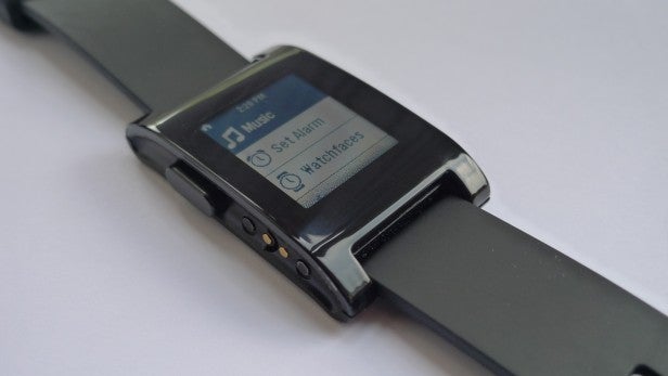 Pebble smartwatch displaying music controls on its screen.