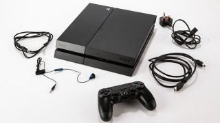 PS4 console with controller and various cables.