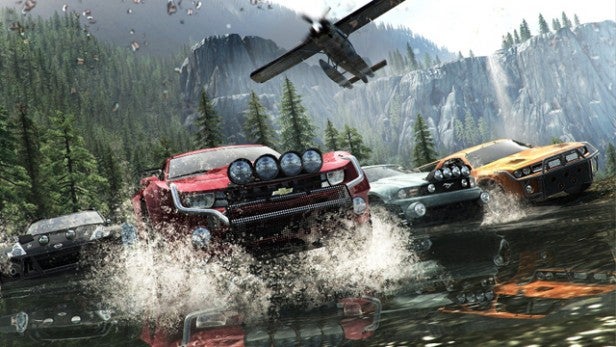 Cars racing through water with a helicopter overhead in 