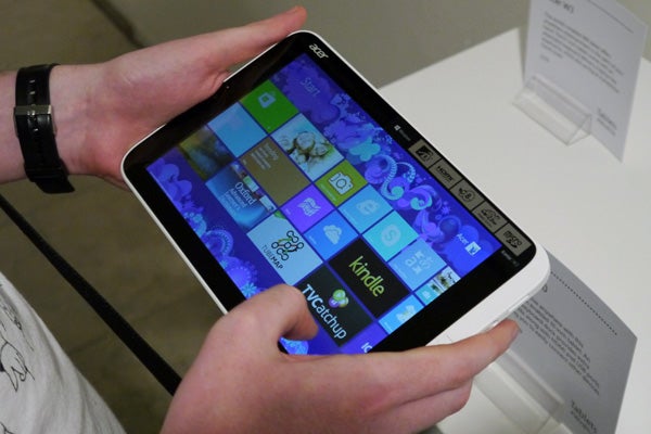 Hand holding Acer Iconia W3 tablet showing ports.