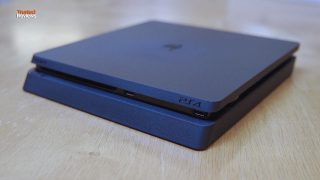 PlayStation 4 Slim console on a wooden surface.