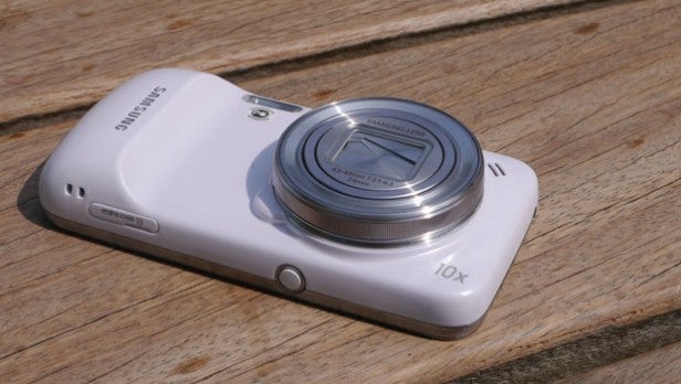 Samsung digital camera with zoom lens on wooden surface.