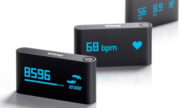 Three Withings Pulse trackers displaying steps and heart rate.