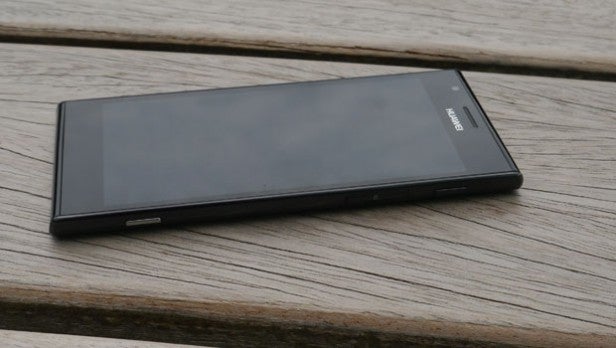 Smartphone lying on a wooden surface for a product review.