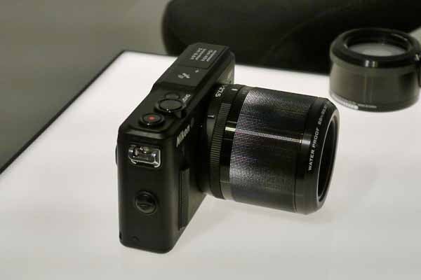 Nikon 1 AW1 camera with zoom lens on table