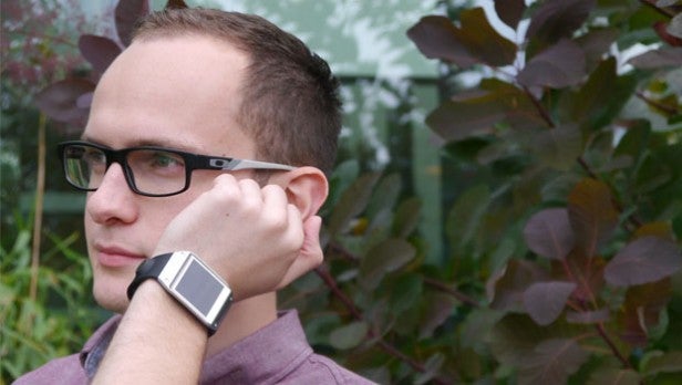 Man wearing smartwatch while touching its screen.