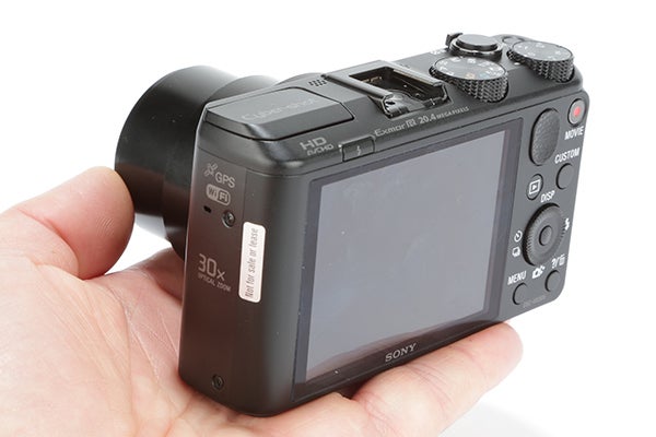 Sony Cyber-shot HX50 camera held in hand, rear view.