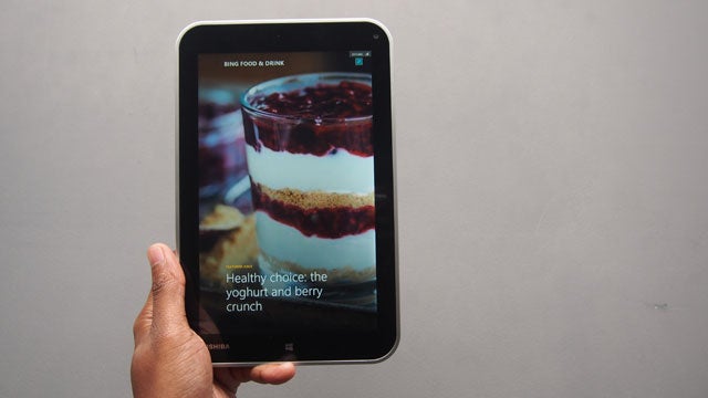 Hand holding Toshiba Encore tablet displaying food app.