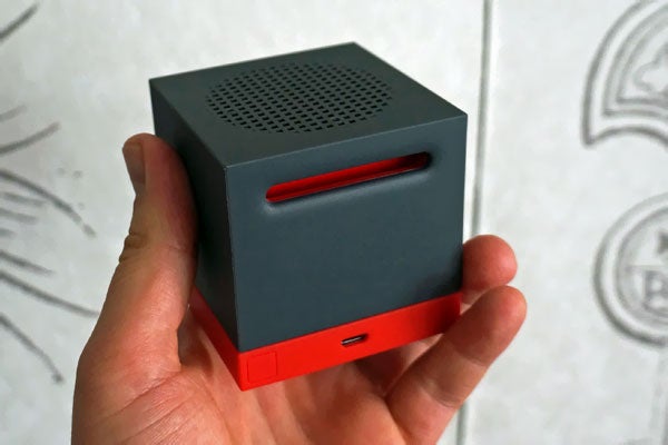 HTC BoomBass speaker held in a person's hand.