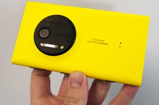 Hand holding a yellow Nokia Lumia 1020 smartphone