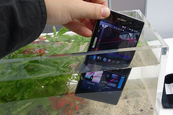 Hand holding Sony Xperia Z1 above water to show waterproof feature.