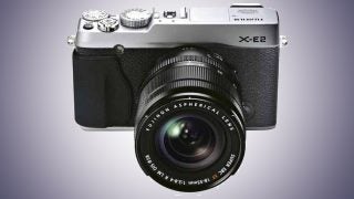 Fujifilm X-E2 mirrorless camera with lens on white background.