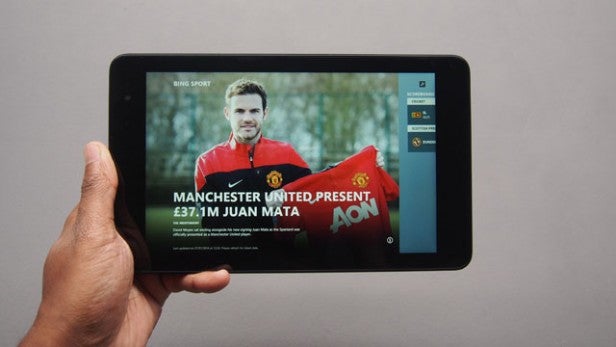 Hand holding a Dell Venue Pro 8 displaying a sports news article.