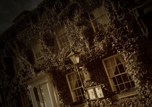 Sepia-toned photo of a vine-covered building facade.