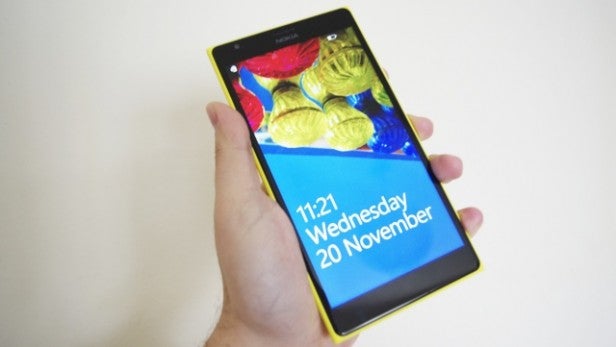 Hand holding Nokia Lumia 1520 displaying colorful screen.