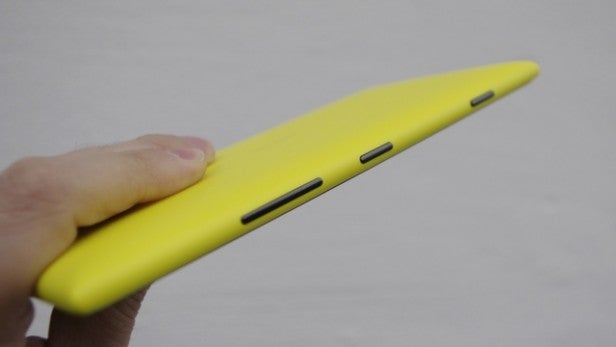 Hand holding a yellow Nokia Lumia 1520 smartphone.