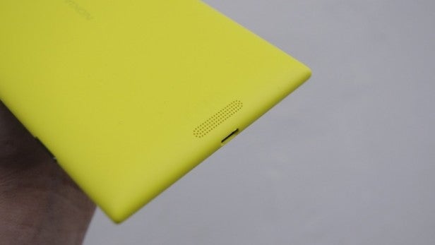 Close-up of a yellow smartphone's battery charging port.
