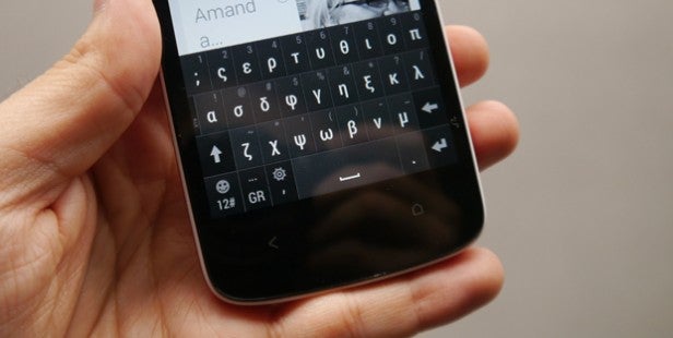 Hand holding smartphone with on-screen keyboard displayed