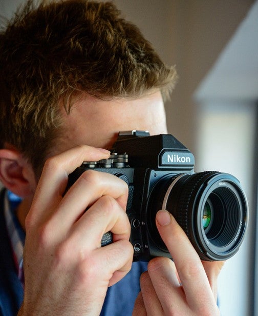 Person taking a photo with a Nikon DSLR camera.