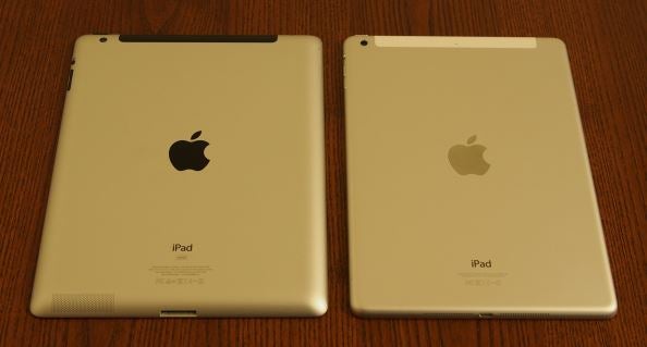 Two iPad Air models side by side on wooden surface.