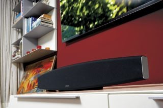 Monitor Audio ASB-2 soundbar on a white cabinet in a living room.