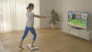Person using Wii Fit U balance board during a game.