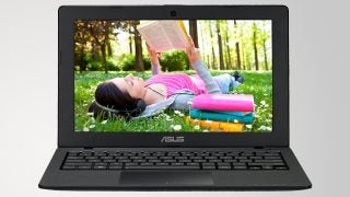 Asus X200CA laptop with user enjoying music in a park.