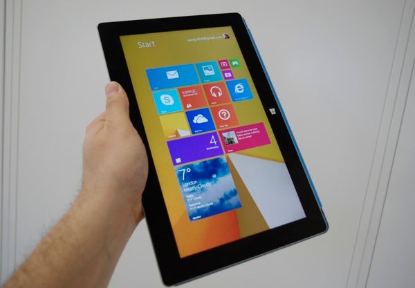 Hand holding a Microsoft Surface 2 tablet displaying start screen